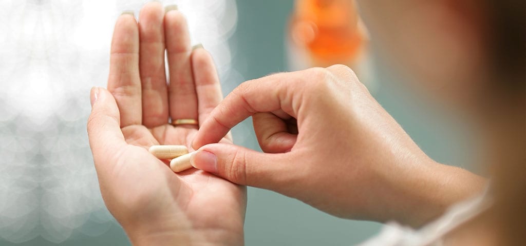 Woman taking supplement pill