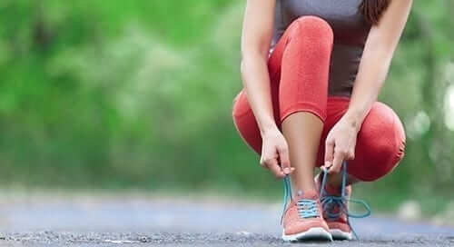 Woman Tying Shoe While Exercising