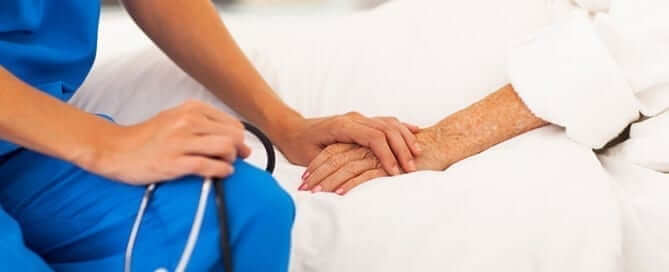 Medical professional holding patients hand