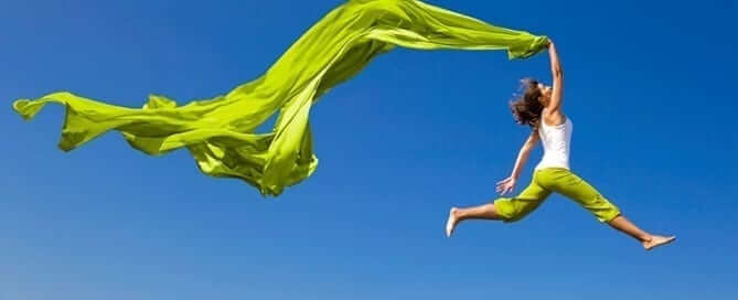 Woman with green sheet leaping