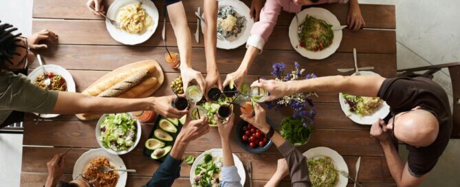 Group of friends toasting drinks and enjoying diabetes-friendly food