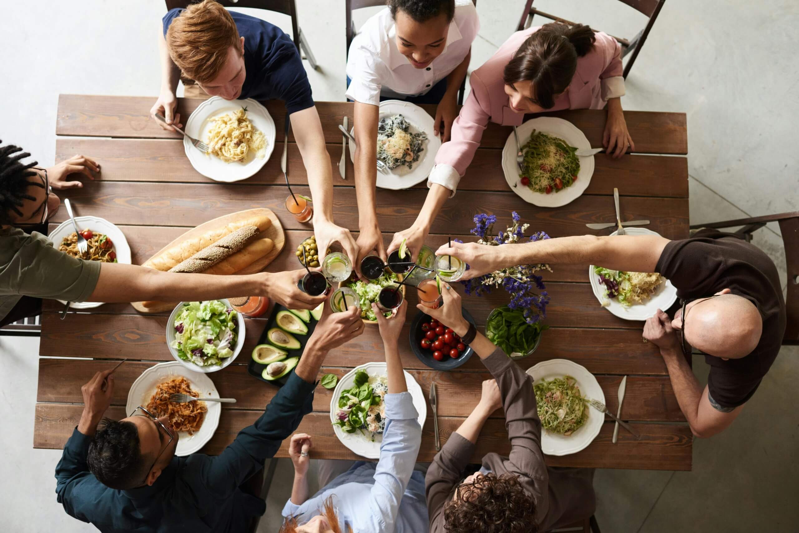 Group of friends toasting drinks and enjoying diabetes-friendly food