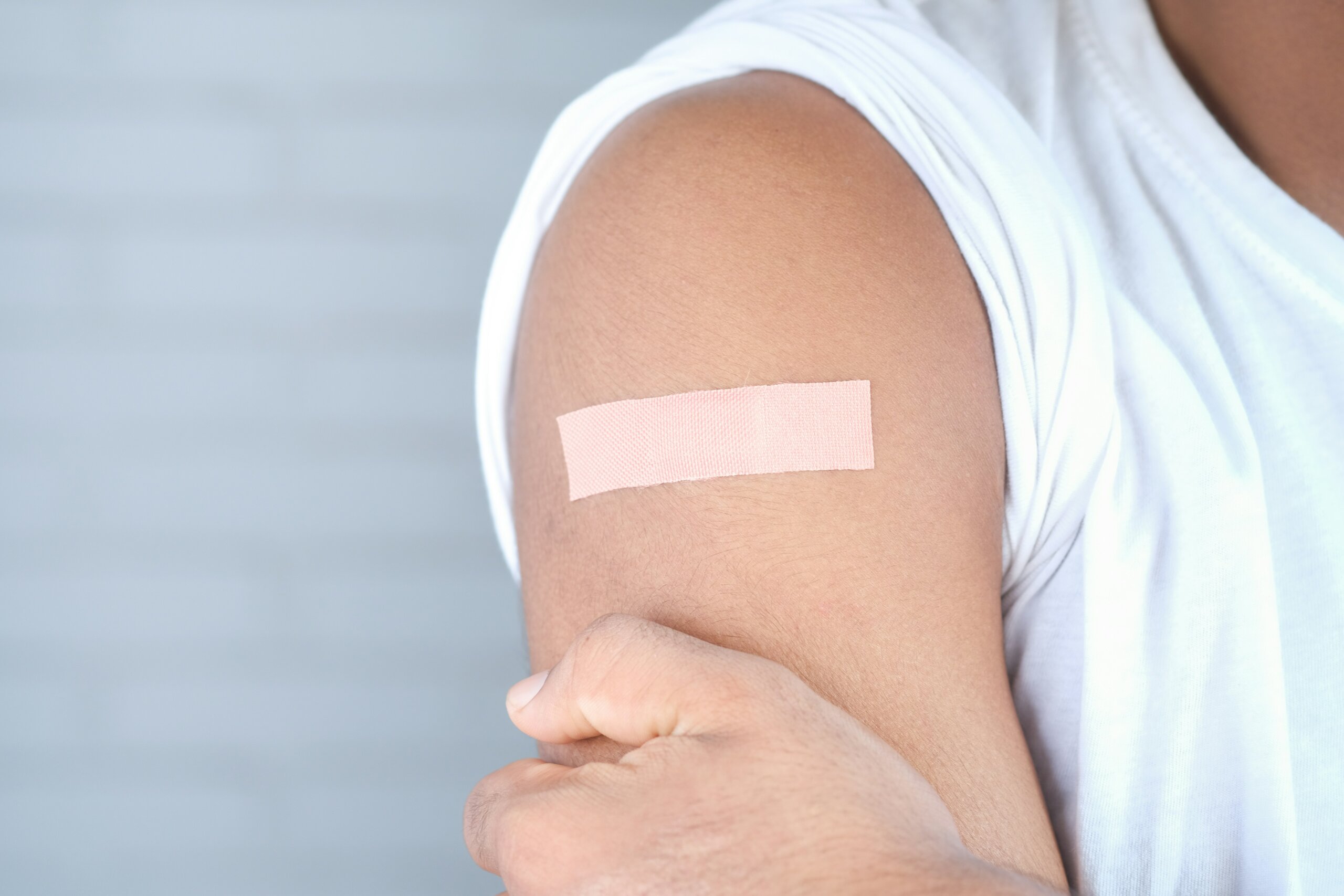 A person's upper arm dressed with medical tape