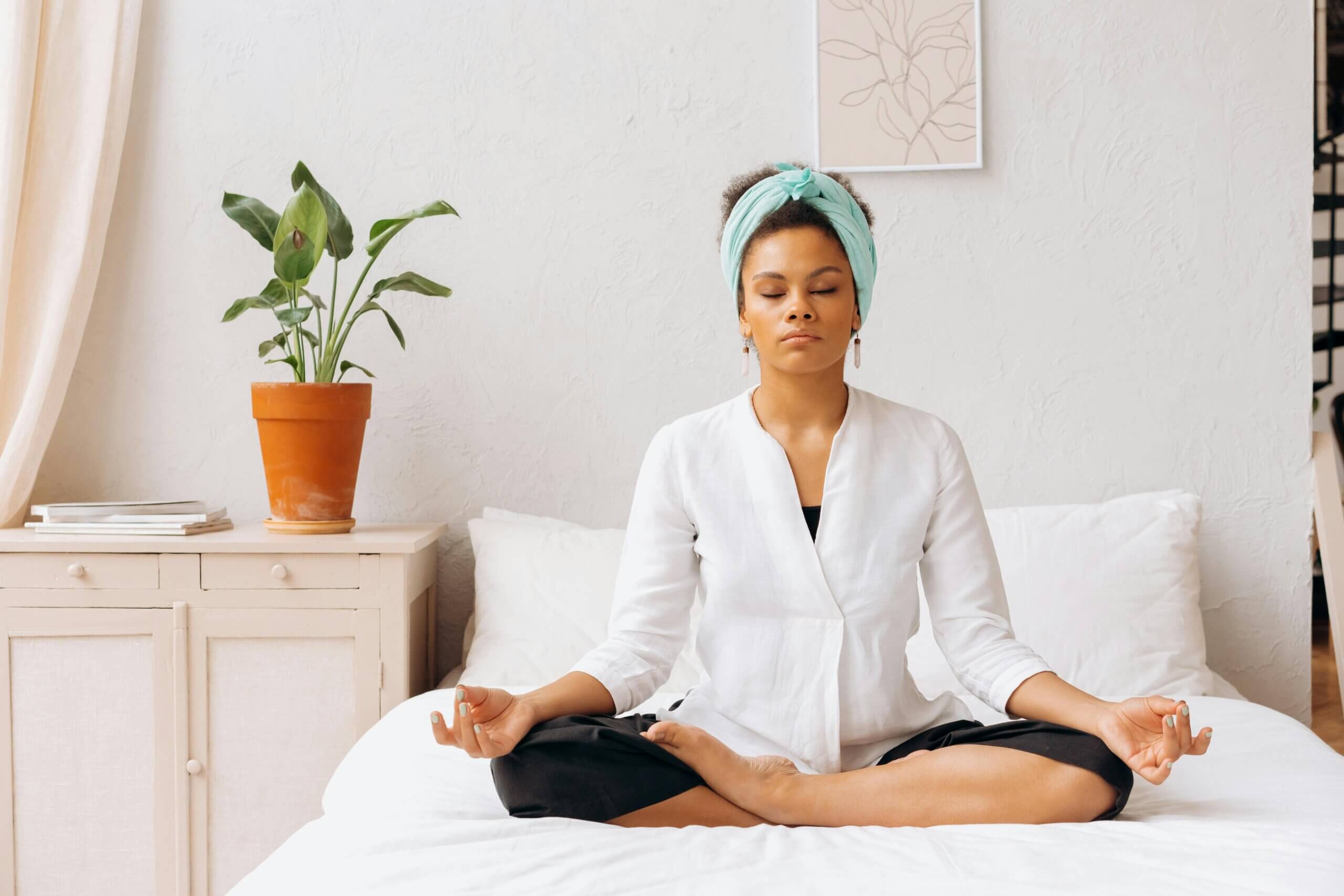 A woman meditating on her bed