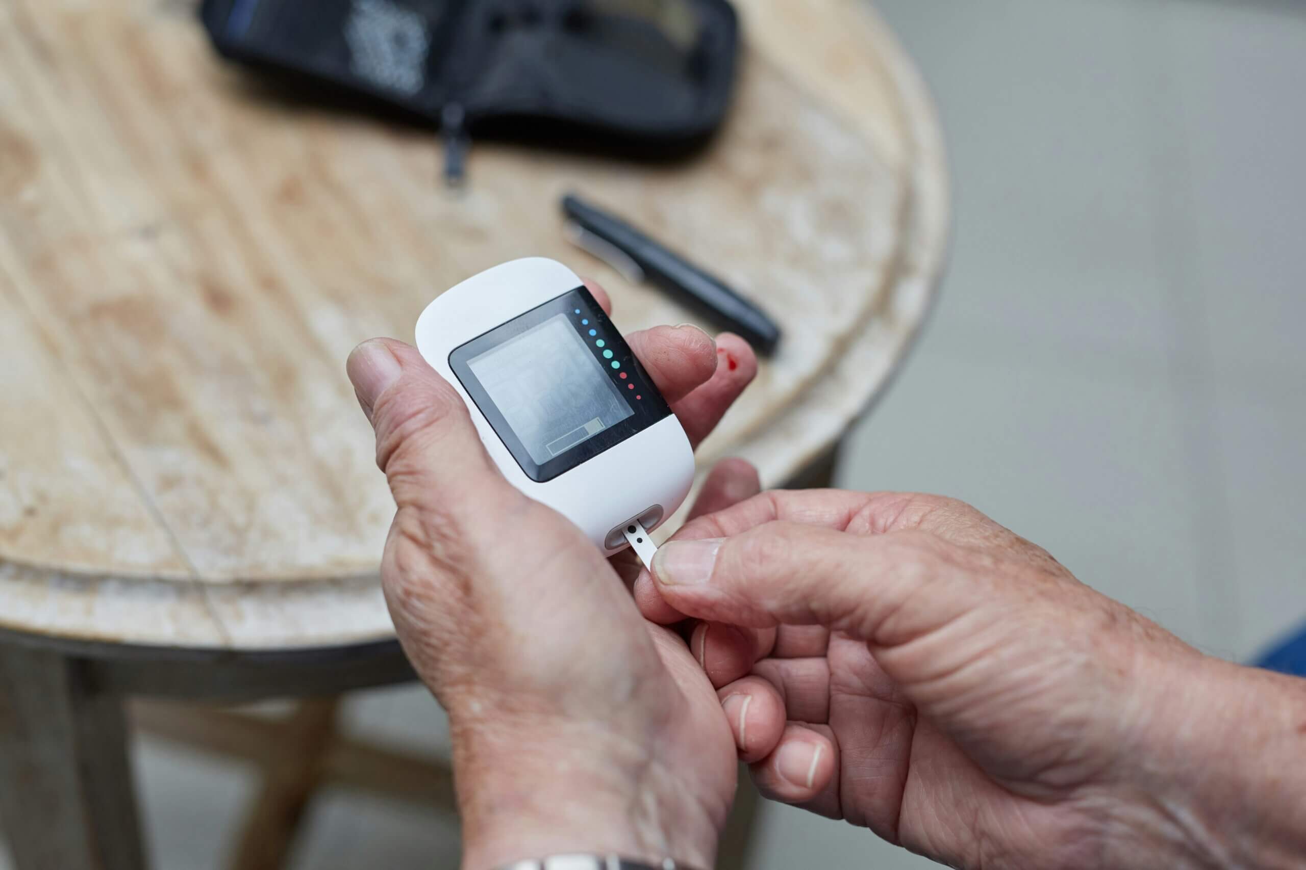 A person inserting a test strip into a glucometer